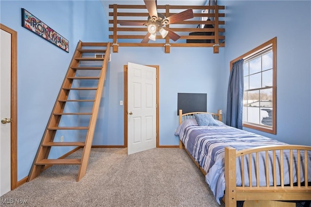 bedroom with a towering ceiling, baseboards, and light colored carpet