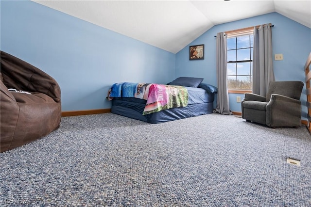 carpeted bedroom with baseboards and vaulted ceiling