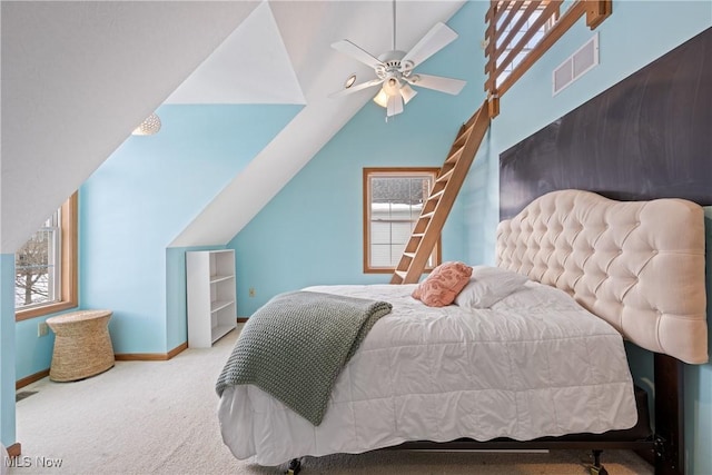 carpeted bedroom with lofted ceiling, baseboards, visible vents, and a ceiling fan