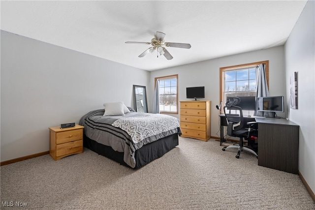 carpeted bedroom with multiple windows, ceiling fan, and baseboards