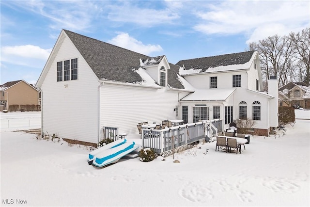 snow covered house featuring a deck