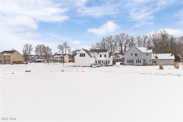 yard layered in snow featuring a residential view