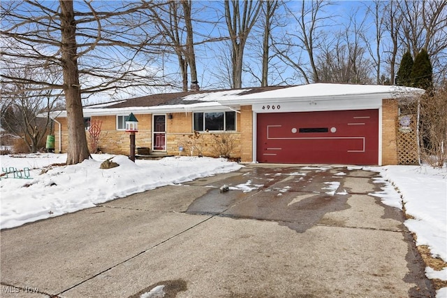 single story home with an attached garage, driveway, and brick siding