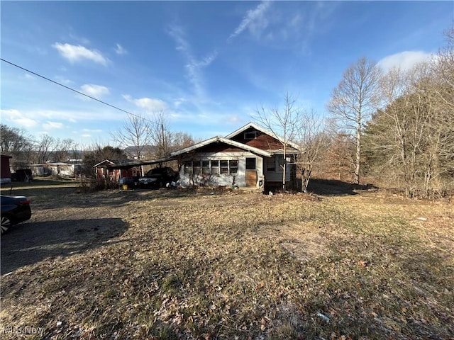 view of front of home with an attached carport and dirt driveway