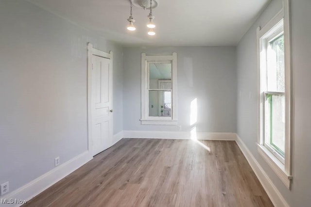 spare room with light wood-type flooring and baseboards