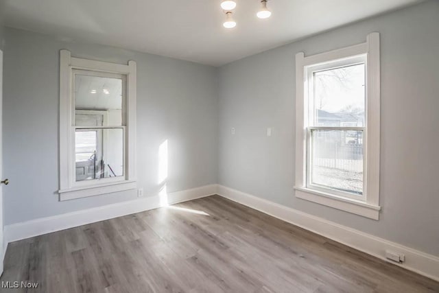 empty room with baseboards and wood finished floors