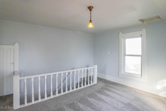 carpeted spare room with attic access