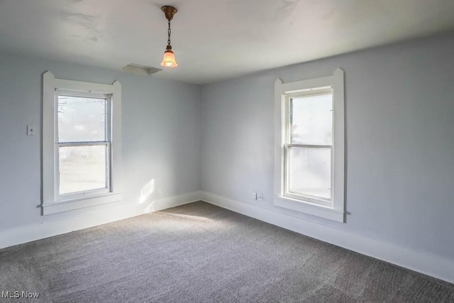 spare room featuring carpet flooring and baseboards