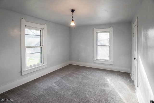 carpeted empty room with a healthy amount of sunlight and baseboards