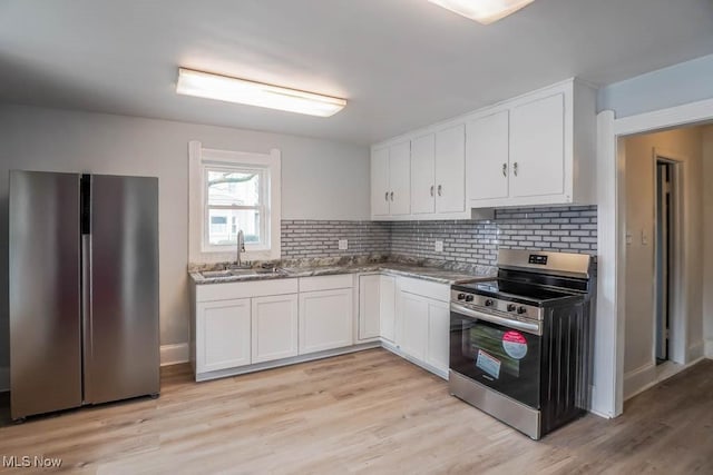 kitchen with stainless steel appliances, white cabinetry, a sink, and decorative backsplash