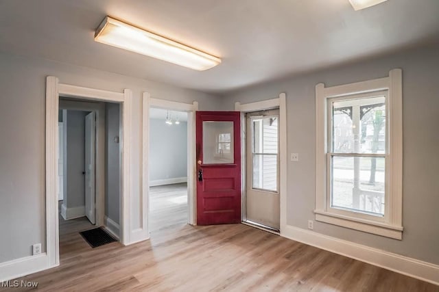 foyer with light wood-type flooring and baseboards