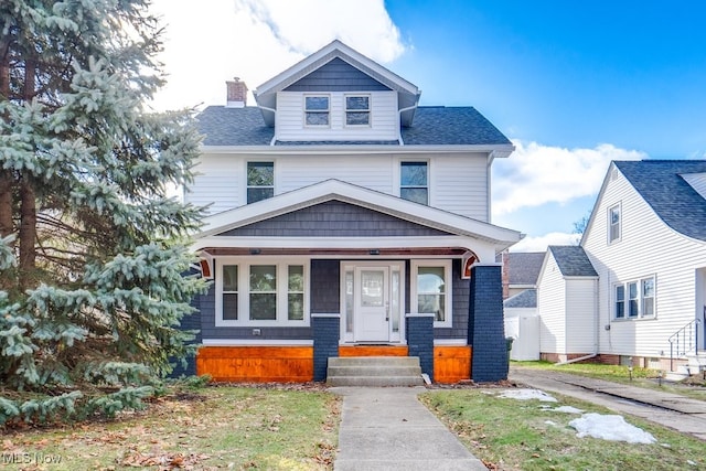 american foursquare style home featuring entry steps, a shingled roof, and a chimney