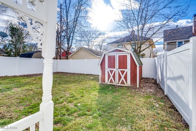 view of yard with an outbuilding, a storage unit, and a fenced backyard