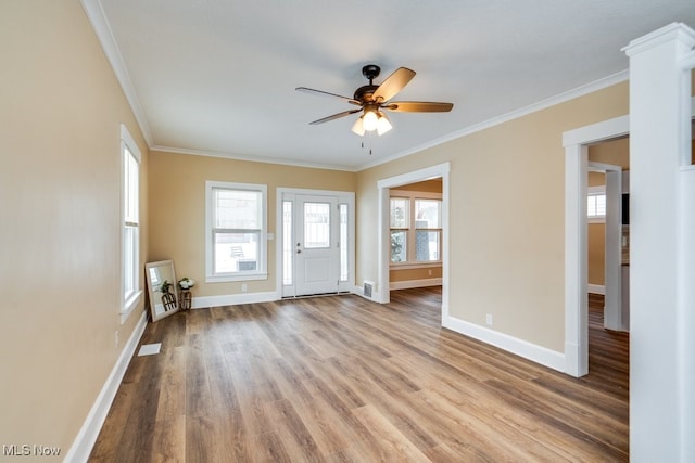 entryway with ornamental molding, light wood-type flooring, and baseboards