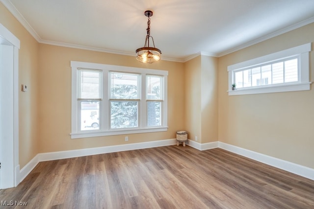 unfurnished room with ornamental molding, wood finished floors, and baseboards