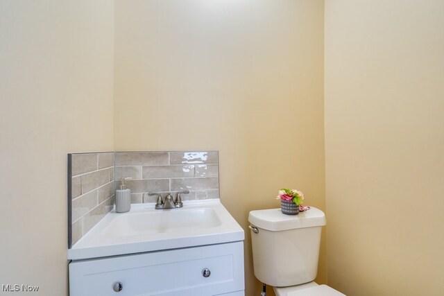 bathroom with tasteful backsplash, vanity, and toilet