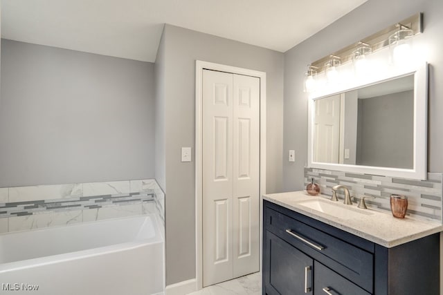 bathroom with a bath, marble finish floor, a closet, and vanity