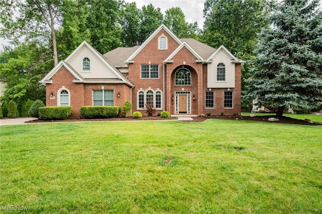 view of front facade featuring brick siding and a front lawn