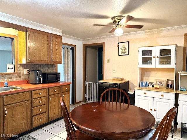 kitchen featuring black microwave, light countertops, brown cabinets, and decorative backsplash