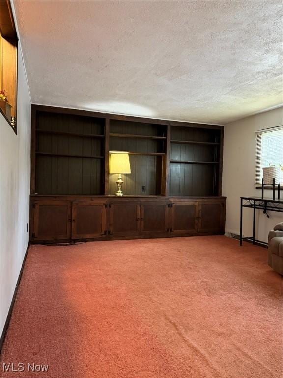 unfurnished living room featuring light carpet and a textured ceiling