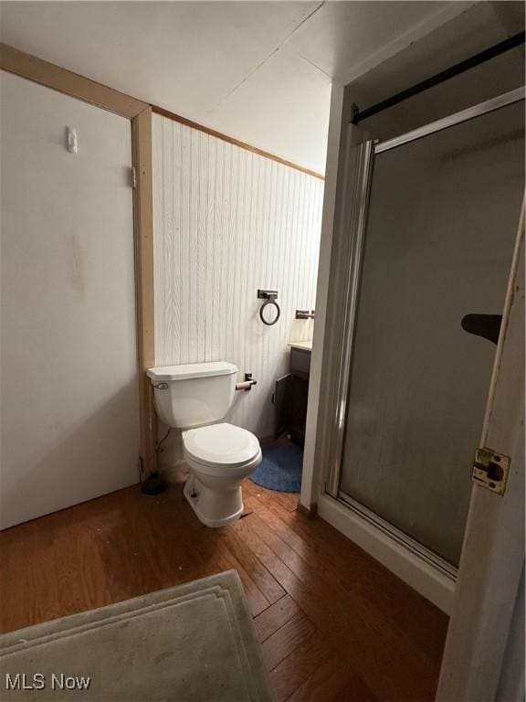 full bathroom with a stall shower, wood-type flooring, and toilet