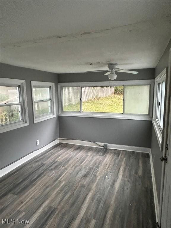 unfurnished sunroom featuring a ceiling fan and a healthy amount of sunlight