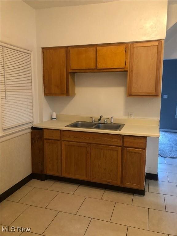 kitchen featuring brown cabinets, light countertops, and a sink