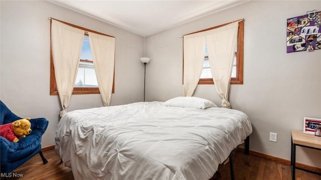 bedroom with dark wood finished floors and baseboards