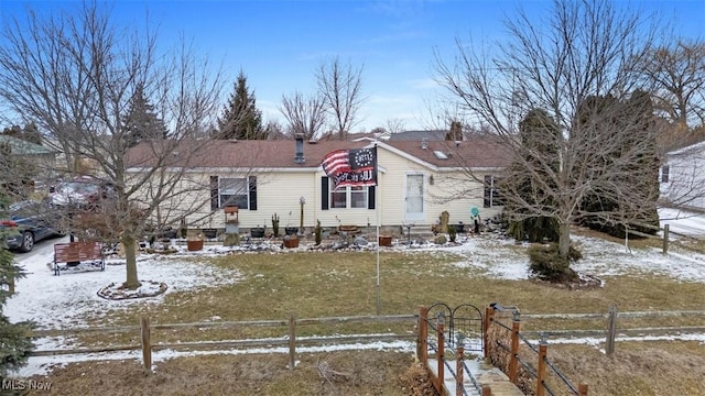 view of front of home with a yard, entry steps, and fence