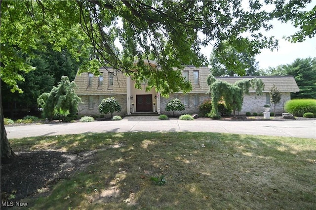 view of front of property with stone siding and a front lawn