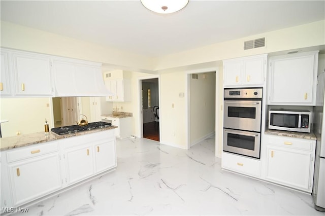 kitchen featuring marble finish floor, visible vents, appliances with stainless steel finishes, white cabinetry, and light stone countertops