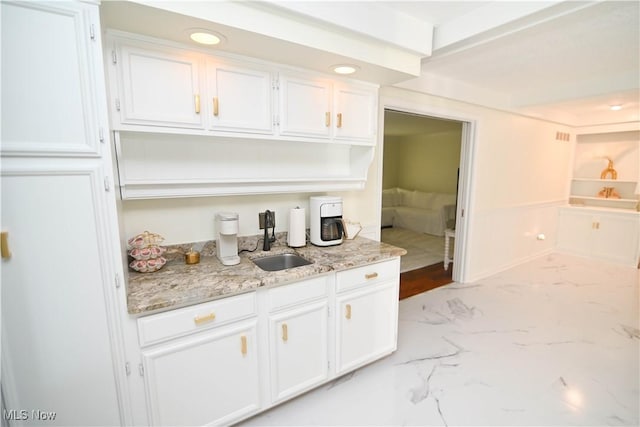 bar with recessed lighting, marble finish floor, and a sink