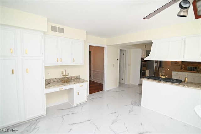 kitchen featuring double oven, visible vents, white cabinetry, a ceiling fan, and marble finish floor