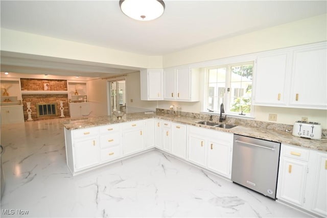 kitchen featuring a sink, a peninsula, white cabinets, and dishwasher