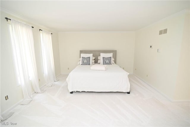 bedroom with visible vents, crown molding, and light colored carpet