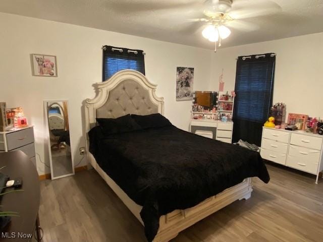 bedroom with a ceiling fan and dark wood finished floors