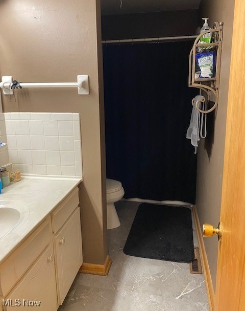 bathroom with baseboards, vanity, and toilet