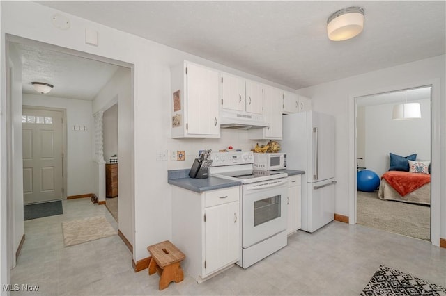 kitchen featuring under cabinet range hood, white appliances, white cabinets, light floors, and tasteful backsplash