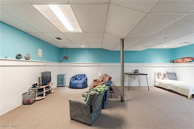 living area featuring carpet, visible vents, and a drop ceiling