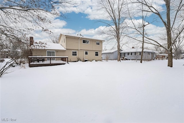 snow covered property with a deck