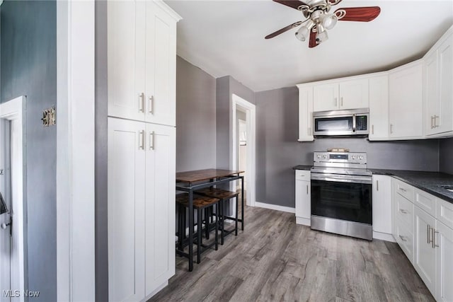 kitchen featuring dark countertops, white cabinets, and stainless steel appliances