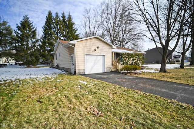 view of side of property with a garage, driveway, and a yard