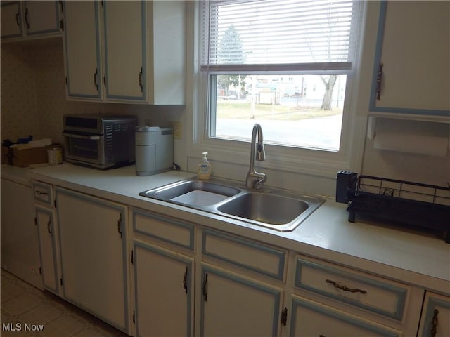 kitchen featuring light countertops and a sink