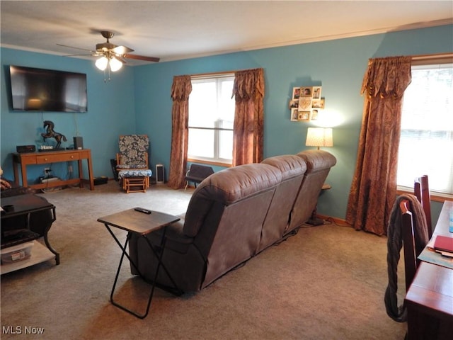 living room with baseboards, carpet, a ceiling fan, and a healthy amount of sunlight