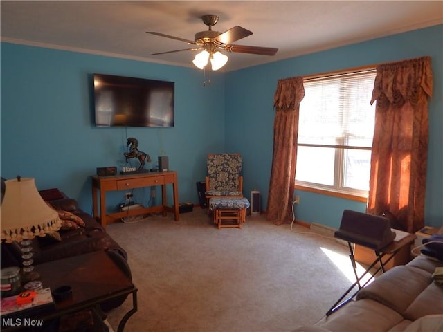 living area with baseboards, carpet flooring, a ceiling fan, and crown molding