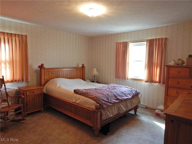 carpeted bedroom with a textured ceiling and wallpapered walls