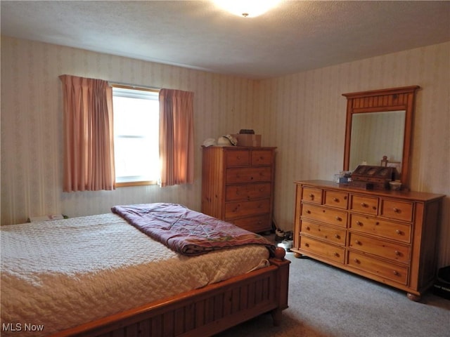 bedroom with carpet floors and wallpapered walls