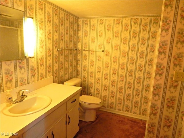 bathroom with toilet, wallpapered walls, a shower, and vanity