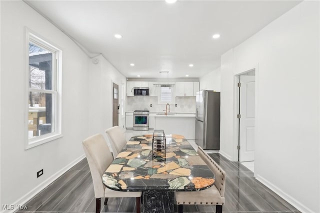 dining space with baseboards, dark wood-type flooring, and recessed lighting