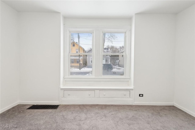 spare room featuring light carpet, visible vents, and baseboards